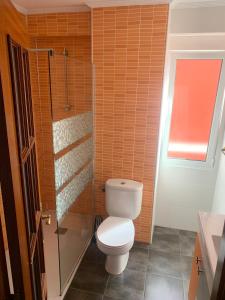 a bathroom with a toilet and a glass shower at Apartamento Santander in Santander