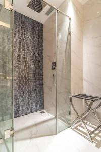 uma cabina de duche em vidro com uma cadeira na casa de banho em The Rixx Central @ Park Hyatt/SmartTV65in/Netflix em Ho Chi Minh