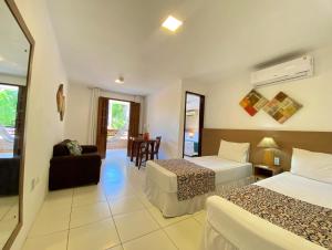 マラゴージにあるPousada Encontro das Águasのベッド2台とリビングルームが備わるホテルルームです。