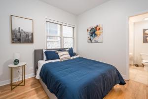 a bedroom with a bed and a bathroom with a sink at Vibrant and Modern 2-Bedroom Home Near Downtown in Chicago