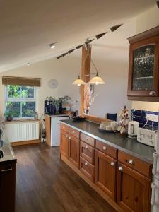 a kitchen with wooden cabinets and a black counter top at Hilltop Cottage in Thropton