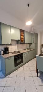 cocina con electrodomésticos de acero inoxidable y suelo de baldosa en Homelike City Apartment, en Viena