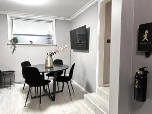 a dining room with a black table and chairs at Mos Appartment in Reykjavík