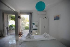 ティロスにあるKarantouの白いベッドルーム(ベッド1台、鏡付)