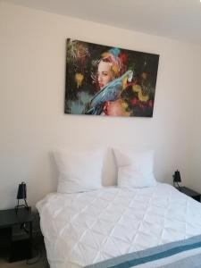 ein Gemälde an der Wand über einem Bett in der Unterkunft Weyersheim 3 Pieces "JOE" in Weyersheim