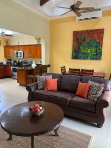 sala de estar con sofá marrón y mesa en Macaws Ocean Club Apartamento # 18, en Jacó