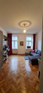 sala de estar con sofá azul y suelo de madera en Homelike City Apartment, en Viena