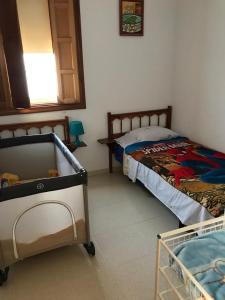 ein Schlafzimmer mit 2 Betten und einem Kinderbett in der Unterkunft Camelot in Arona