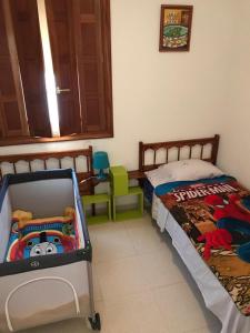 ein Schlafzimmer mit einem Bett und einem Kinderbett in der Unterkunft Camelot in Arona