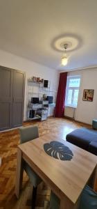 een woonkamer met een houten tafel en een bank bij Homelike City Apartment in Wenen