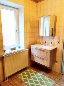 a bathroom with a sink and a mirror and a window at Ferienwohnung Hölscher in Ascheberg