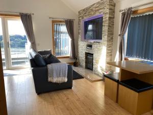 a living room with a couch and a fireplace at The Chalet, 444 North Lochboisdale in Lochboisdale