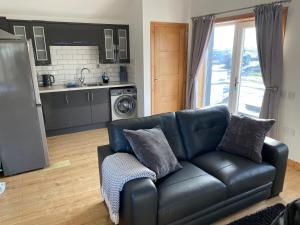 a living room with a couch and a kitchen at The Chalet, 444 North Lochboisdale in Lochboisdale