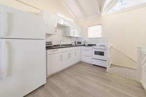 a white kitchen with white appliances and a window at La Vista Resort in Simpson Bay