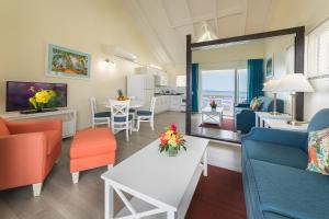 a living room with orange and blue furniture and a table at La Vista Resort in Simpson Bay