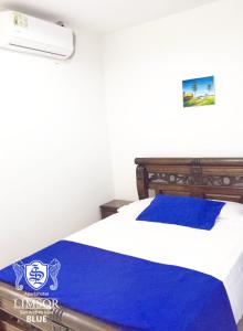 sypialnia z łóżkiem z niebieskim kocem w obiekcie Apartahotel Limsor Blue w mieście San Andrés