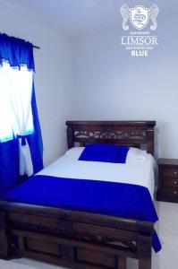 sypialnia z łóżkiem z niebieską pościelą w obiekcie Apartahotel Limsor Blue w mieście San Andrés