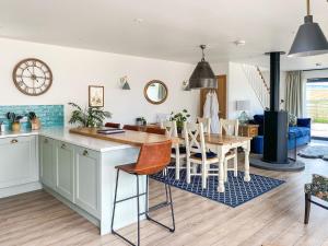 a kitchen and living room with a table and chairs at The Cart House in Duns