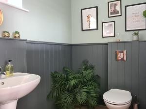 a bathroom with a sink and a toilet and a plant at The Cart House in Duns