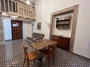 ナポリにあるTribunali apartmentsのリビングルーム(テーブル、椅子、ソファ付)