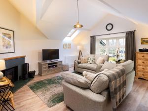 a living room with a couch and a tv at Tilly's Cottage in Grasmere