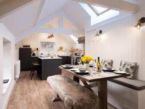 a kitchen with a wooden table and a dining room at Tilly's Cottage in Grasmere