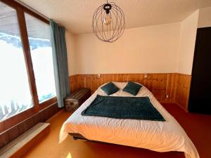 a bedroom with a bed and a chandelier at Carlines'home in Les Orres
