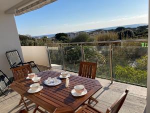 d'une table et de chaises en bois sur un balcon avec vue. dans l'établissement Blue Sardinia Tourism, à Budoni