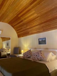 1 dormitorio con 1 cama grande y techo de madera en Maison Des Fleurs, en Nápoles