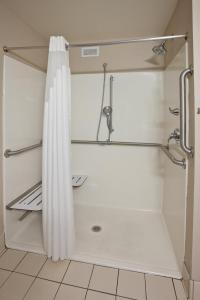 a shower with a white shower curtain in a bathroom at Holiday Inn Express and Suites St. Cloud by IHG in Saint Cloud