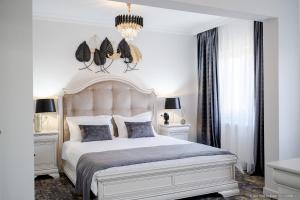 - une chambre avec un grand lit blanc et 2 tables de chevet dans l'établissement Tesa Boutique Hotel, à Tîrgu Neamţ