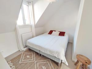een witte slaapkamer met een bed en een raam bij L'Escampette, Duplex T3, centre Luchon, wifi, casier à skis, 4 personnes in Luchon