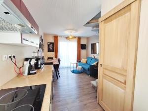 a kitchen with a counter top and a living room at L'Escampette, Duplex T3, centre Luchon, wifi, casier à skis, 4 personnes in Luchon