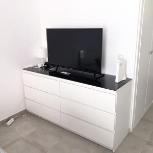 a white dresser with a tv on top of it at Sunny Suites Jupiter Apartments in Benalmádena