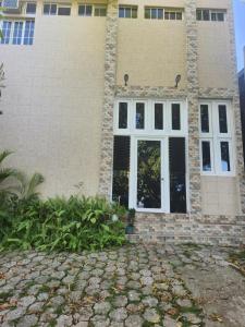 une maison avec 2 fenêtres et une allée en pierre dans l'établissement Hotel Casa de Don Francisco, à Flores