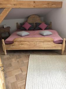 - une chambre dotée d'un lit en bois avec des draps et des oreillers roses dans l'établissement Ferienwohnung / Appartement Bergliebe, à Garmisch-Partenkirchen