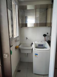 a small bathroom with a sink and a washing machine at Vista para a Orla de VV in Vila Velha