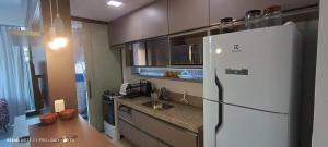 a kitchen with a white refrigerator and a sink at Vista para a Orla de VV in Vila Velha