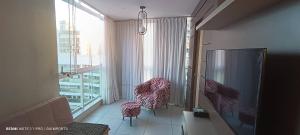 a room with two chairs and a large window at Vista para a Orla de VV in Vila Velha