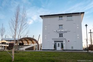 a white building with a sign on the side of it at Tesa Boutique Hotel in Târgu Neamț