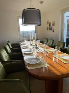 a long wooden table with chairs and a large table with glasses at Penthouse perfekt für Teams, Familien und Gruppen in Bad Mergentheim
