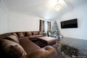 Tesa Boutique Hotel في تارجو نيمت: غرفة معيشة مع أريكة وشجرة عيد الميلاد