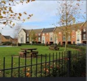 a park with a picnic table and a building at Broughton Haven 5 Beds House Free WiFi, Free parking, NETFLIX in Milton Keynes