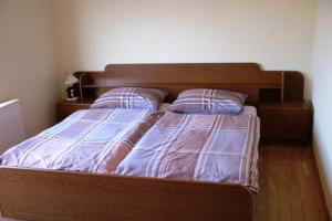 una camera con letto in legno e 2 cuscini di Apartman Darko a Kupres