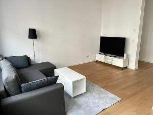 a living room with a couch and a flat screen tv at Modern Apartment in the center of Munich in Munich