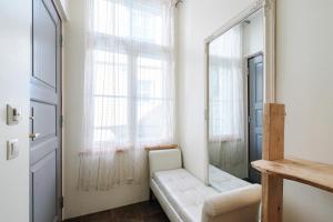 een woonkamer met een witte bank en een spiegel bij AirHome - Owl's Nest 2 in Tallinn +15 foto's