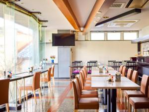 un restaurant avec des tables et des chaises et une télévision à écran plat dans l'établissement Hotel Tsushima - Vacation STAY 64041v, à Tsushima