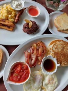 un plato de desayuno con huevos tocino y tostadas en Alla Arriba en Las Cruces