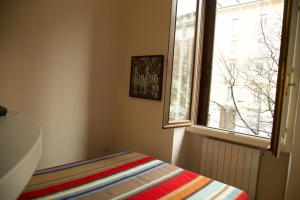ミラノにあるSmart Central Apartments Doriaのベッドルーム1室(窓付)、ベッド1台(ストライプ毛布付)