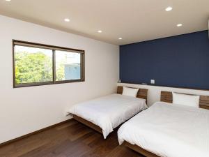 twee bedden in een kamer met een blauwe muur bij Sumoto - Cottage - Vacation STAY 24974v in Sumoto